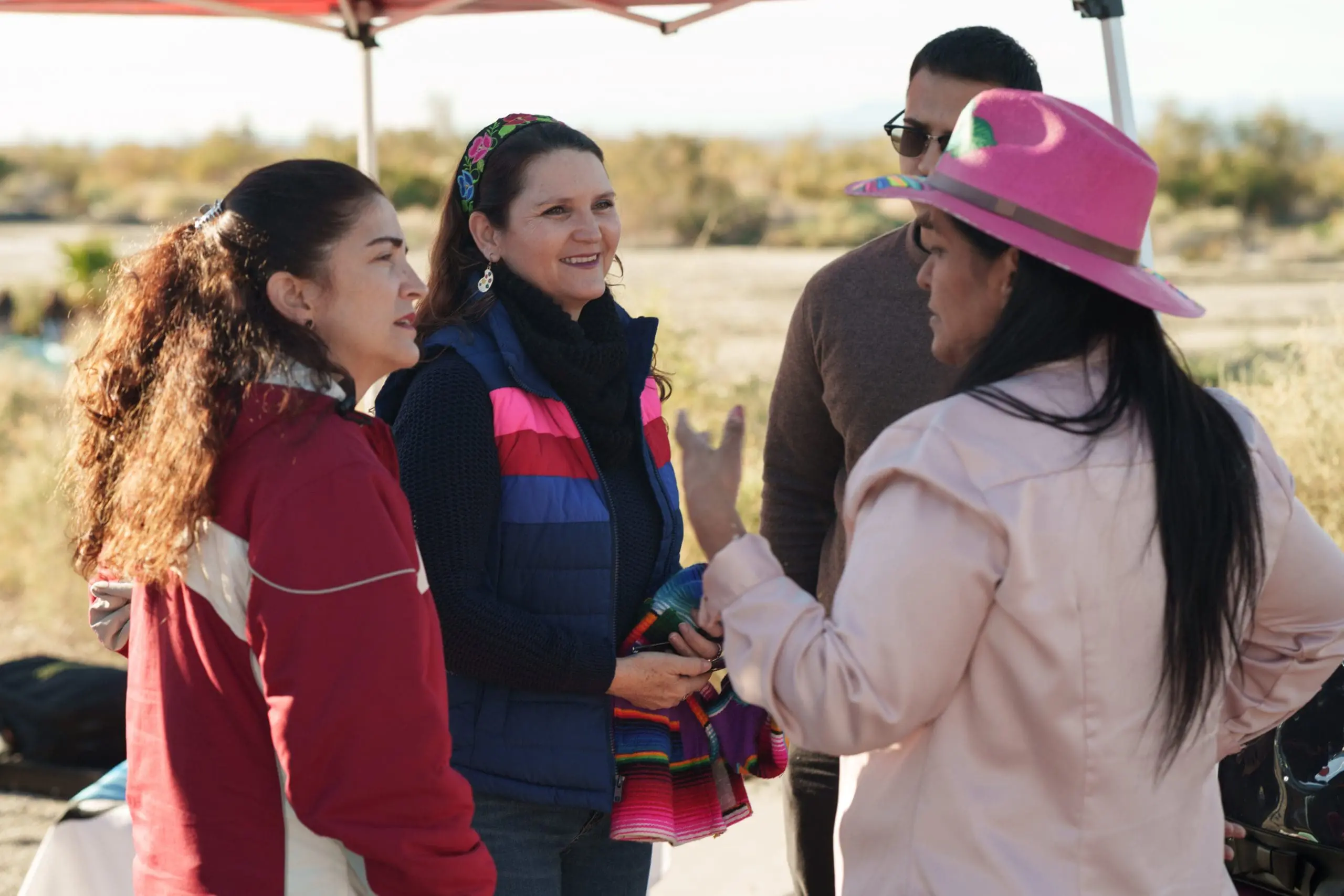 woman talking to another woman with 2 individuals listening